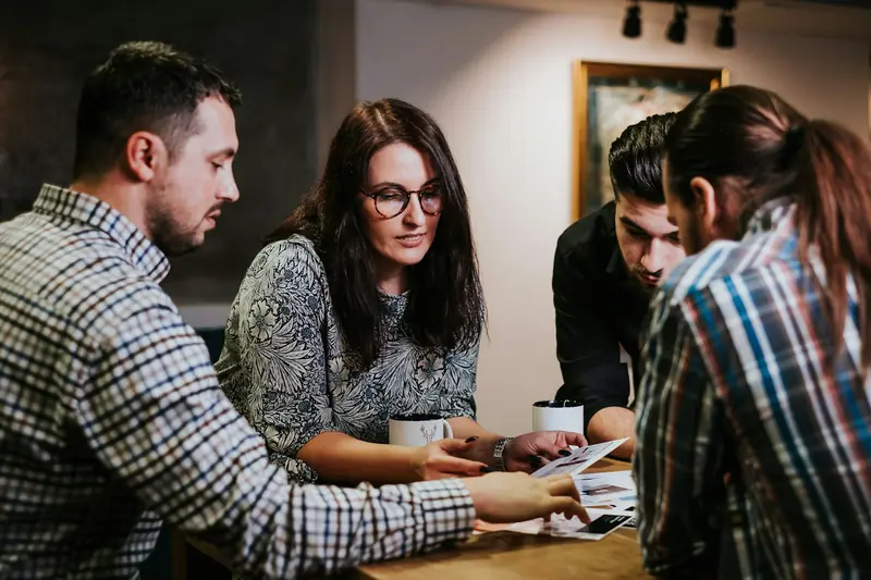 Cuatro personas de un equipo revisando documentos en una mesa